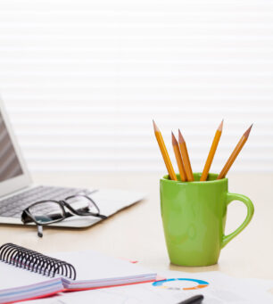 Office workplace with laptop, reports and pencils Office workplace with laptop, reports and pencils on wooden desk table in front of window with blinds